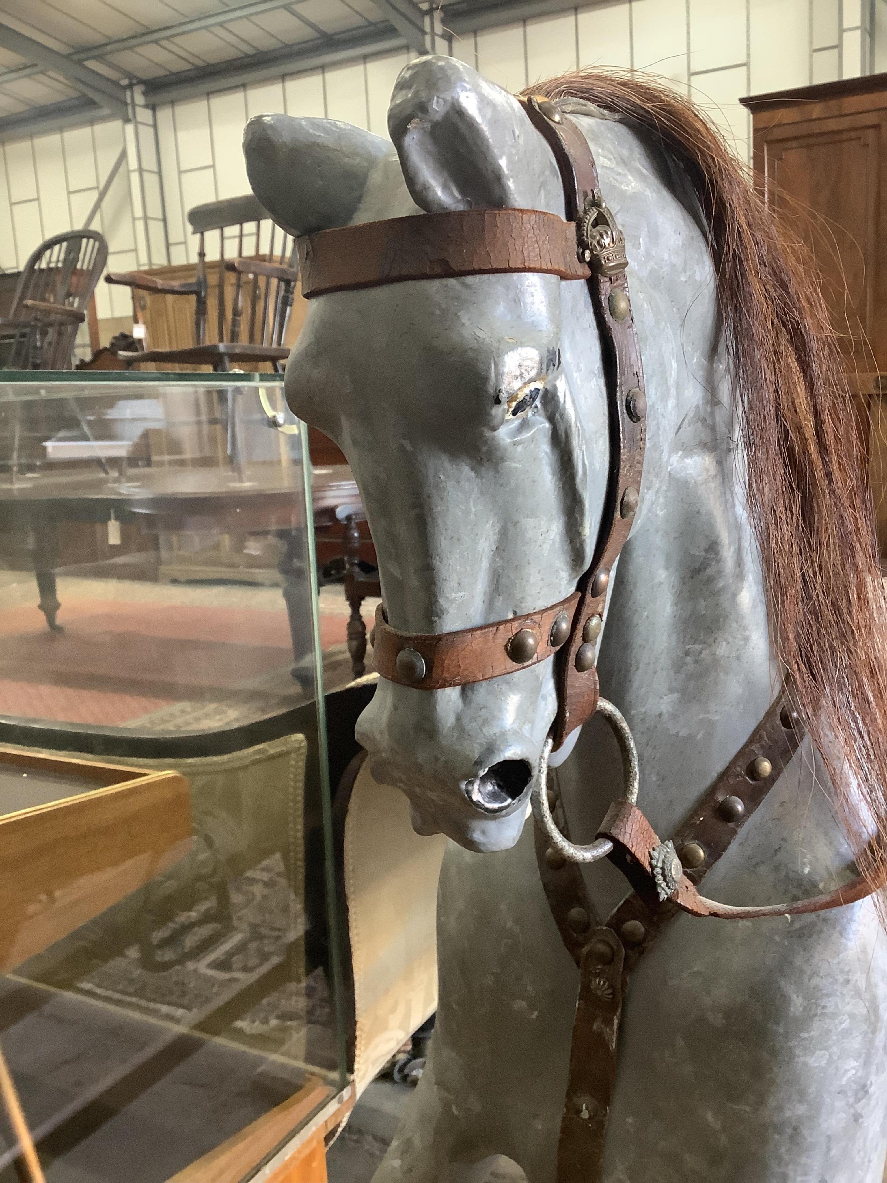 An early 20th century dapple grey rocking horse on pine safety frame, length 136cm, height 108cm. Condition - fair, later painted